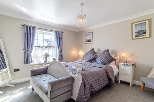 a bedroom with a bed and a couch and a chair at 2 Bed in Wells-next-the-Sea oc-2032 in Wells next the Sea