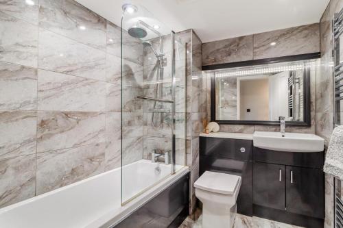a bathroom with a tub and a toilet and a sink at 2 Bed in Wells-next-the-Sea oc-2032 in Wells next the Sea