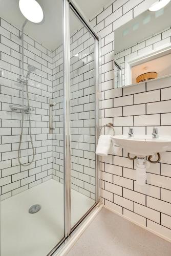 a white bathroom with a shower and a sink at 2 Bed in Sennen oc-flora in Sennen