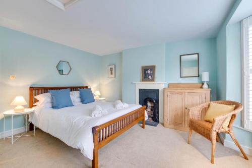 a bedroom with a bed and a chair and a fireplace at 2 Bed in Walberswick oc-hhock in Walberswick