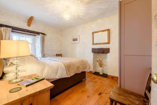 a bedroom with a bed and a table with a lamp at 2 Bed in St Davids oc-30269 in St. Davids