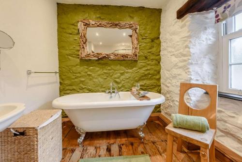 a bathroom with a white tub and a mirror at 2 Bed in St Davids oc-30269 in St. Davids