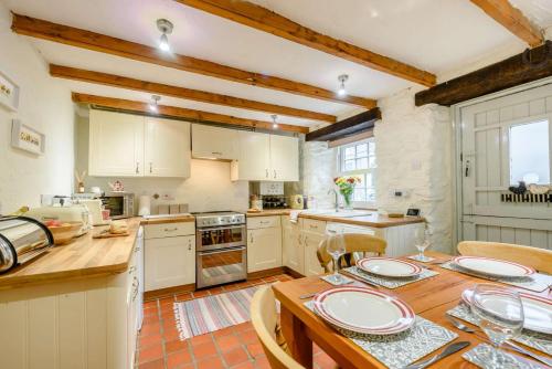 a kitchen with white cabinets and a wooden table at 2 Bed in St Davids oc-30269 in St. Davids