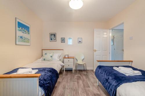a bedroom with two beds and a desk with a chair at 3 Bed in Broad Haven oc-t30529 in Broad Haven