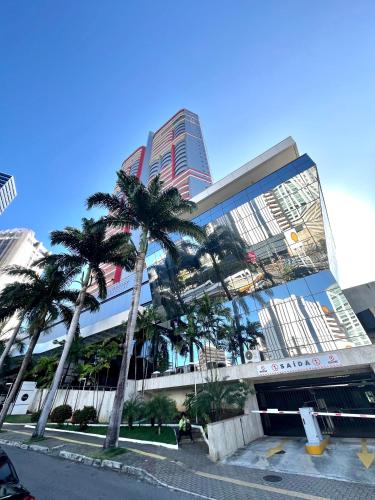 a group of palm trees in front of a building at Mercure1906 - Piscina aquecida, edifício com estrutura de hotel 4 estrelas in Salvador