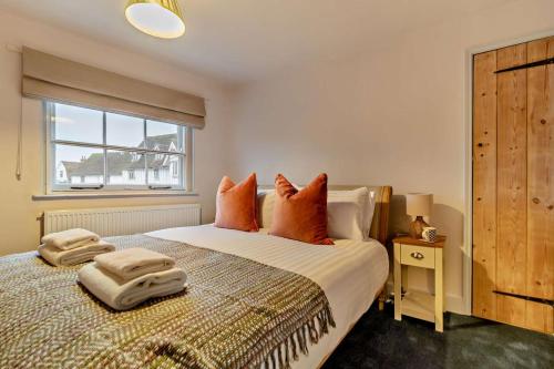a bedroom with a bed with orange pillows and a window at 2 Bed in Lavenham oc-t30056 in Lavenham
