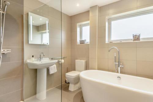a bathroom with a tub and a sink and a toilet at 3 Bed in Westleton oc-egv in Westleton