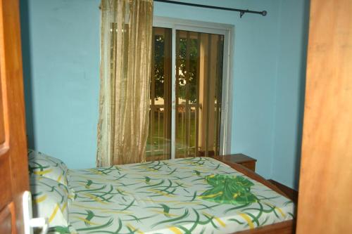 a bedroom with a bed and a window at Résidence cosy proche chûtes de la Lobe in Kribi