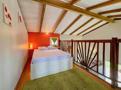 a bedroom with a bed on a balcony at Bungalows Arc en Ciel in Sainte-Anne