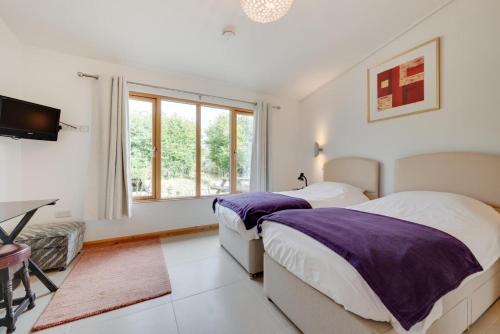 a white bedroom with two beds and a window at 2 Bed in Stelling Minnis oc-ek715 in Lyminge