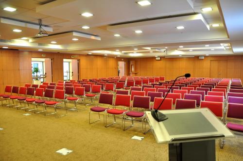 a lecture hall with red chairs and a microphone at Novotel Tunis in Tunis