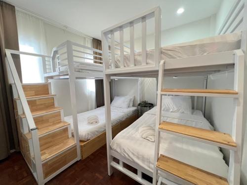 a room with two bunk beds and a staircase at แสงจันทร์พลูวิลล่าระยอง in Ban Thung Haeo