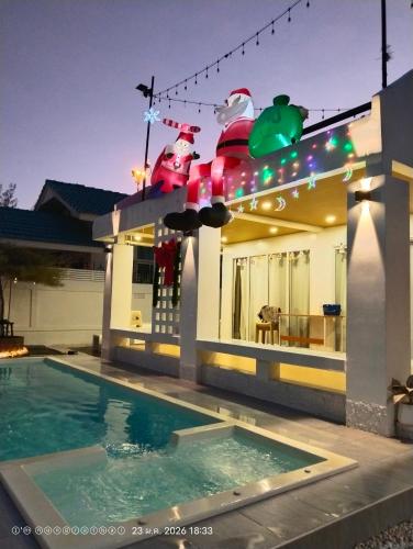 a house with christmas lights on top of a swimming pool at แสงจันทร์พลูวิลล่าระยอง in Ban Thung Haeo