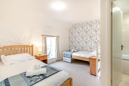 a bedroom with two beds and a window at 2 Bed in Swansea oc-hh403 in Llanmadoc