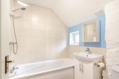 a bathroom with a bath tub and a sink at 2 Bed in Swansea oc-hh403 in Llanmadoc