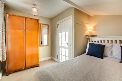 a bedroom with a bed and a wooden cabinet at 3 Bed in Cromer oc-1670 in Cromer