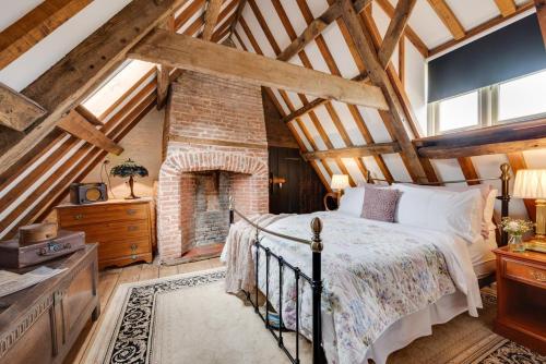 an attic bedroom with a bed and a brick fireplace at 2 Bed in Colkirk oc-1397 in Colkirk