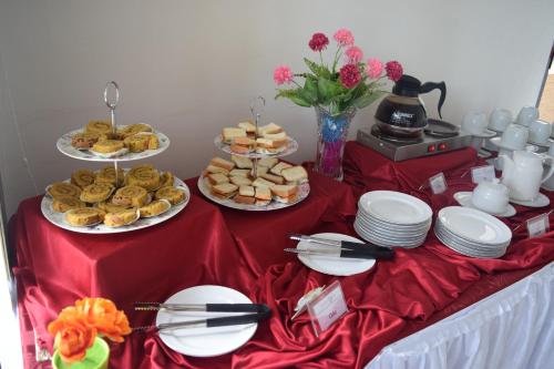 a table with plates of food on a red table cloth at Jambura Inn in Gorontalo