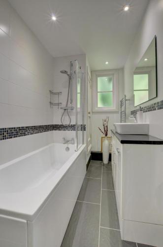 a white bathroom with a large tub and a sink at 4 Bed in Lynmouth oc-marins in Barbrook