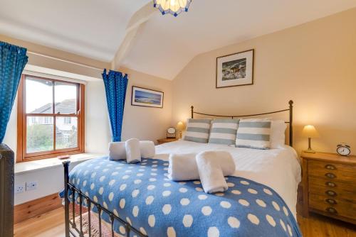 a bedroom with a large bed with blue and white pillows at 2 Bed in St Just oc-crownm in St. Just