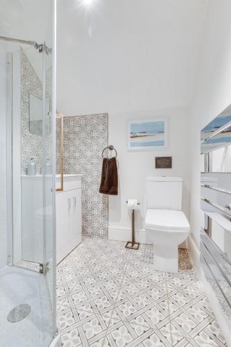 a white bathroom with a toilet and a shower at 3 Bed in Scarborough oc-sa004 in Ravenscar