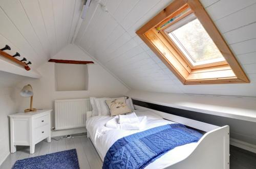 a small attic bedroom with a bed and a window at 3 Bed in Scarborough oc-sa004 in Ravenscar
