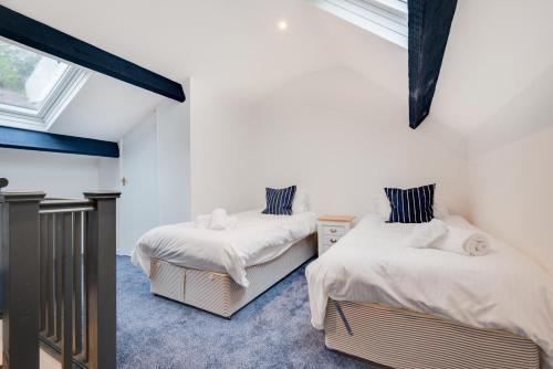 two beds in a room with white walls and a window at 3 Bed in Looe oc-l30071 in Looe