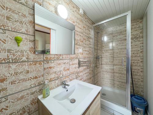 a bathroom with a sink and a mirror and a tub at Bungalows Arc en Ciel in Sainte-Anne