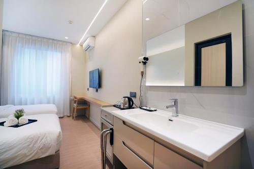 a hotel room with a sink and a bed at ALVILLA Kampung Cina in Kuala Terengganu