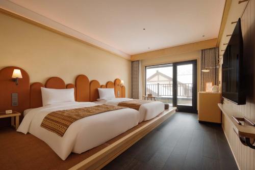 a hotel room with two beds and a flat screen tv at Doradora Boutique Hotel in Fusong