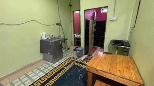 a bathroom with a sink and a table in a room at Studio Khalida Taman Perdana in Pekan