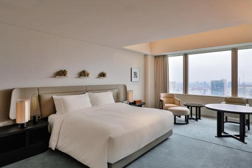 a hotel room with a bed and a large window at Park Hyatt Tokyo in Tokyo