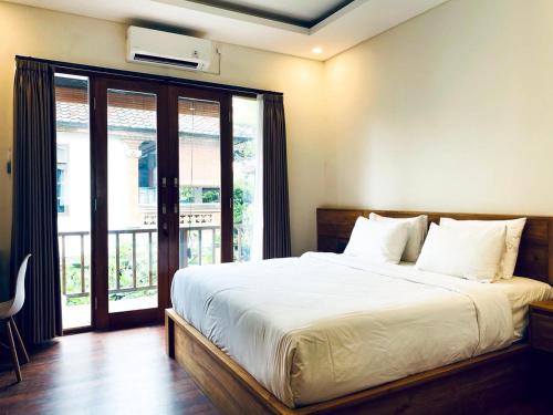 a bedroom with a large bed and a large window at Indarti Living in Sukawati