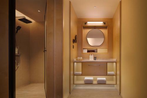 a bathroom with a shower and a sink and a mirror at Doradora Boutique Hotel in Fusong