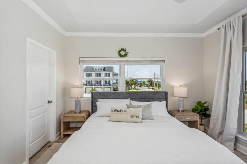 a white bedroom with a large bed and a window at Blue Horizon at Pensacola Beach - Heated Pool, Across beach access, Beach gear, Dogs OK! in Pensacola Beach