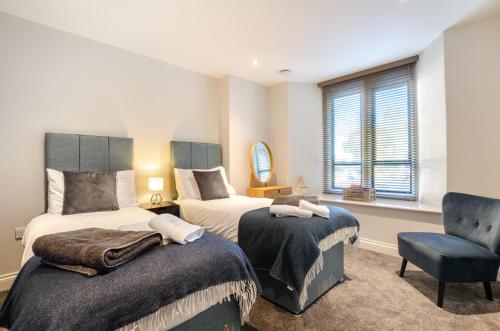 a bedroom with two beds and a chair at 2 Bed in Windermere oc-gl064 in Windermere