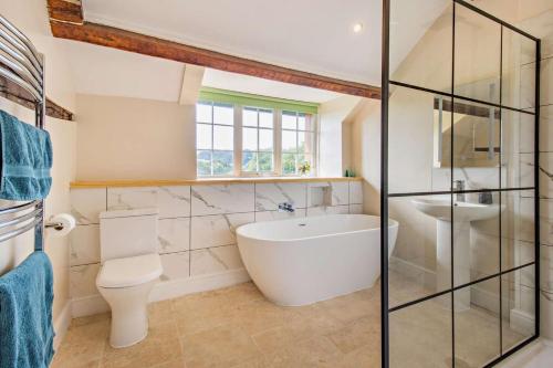 a bathroom with a tub and a toilet and a sink at 3 Bed in Cemmaes Road oc-h29101 in Cemmaes