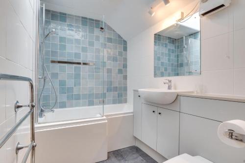 a white bathroom with a sink and a shower at 2 Bed in Bamburgh oc-gd0248 in Bamburgh