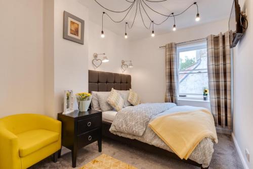 a bedroom with a bed and a yellow chair at 2 Bed in Whitby oc-r563 in Robin Hood's Bay