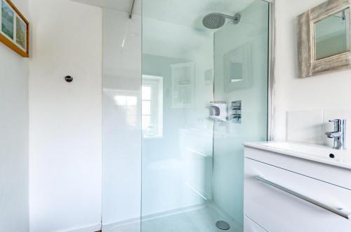 a bathroom with a glass shower and a sink at 1 Bed in Holt oc-1838 in Holt