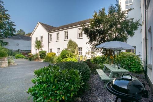 a grill and a picnic table in front of a building at 2 Bed in St. Levan oc-p00851 in Saint Levan