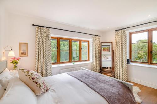 a bedroom with a white bed and windows at 3 Bed in Withypool oc-o18550 in Withypool