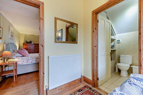 ein Badezimmer mit Toilette, Bett und Spiegel in der Unterkunft 5 Bed in Dre-Fach Felindre oc-c29875 in Felindre
