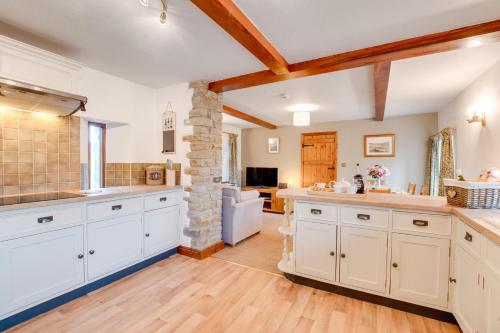 a large kitchen with white cabinets and a stone pillar at 3 Bed in Carperby oc-ds1033 in Carperby