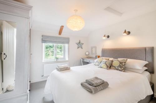 a bedroom with a large white bed with towels on it at 2 Bed in Holt oc-2027 in Thornage