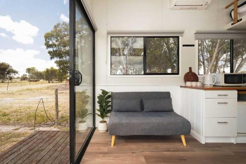 a living room with a couch in a tiny house at Bellellen Park 2 by Tiny Away in Stawell