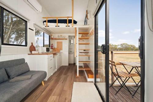 a tiny house with a kitchen and a couch at Bellellen Park 2 by Tiny Away in Stawell