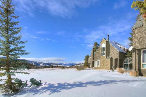 a house in the snow with a tree in the yard at Evergreen Condominiums by Vail Resorts in Keystone