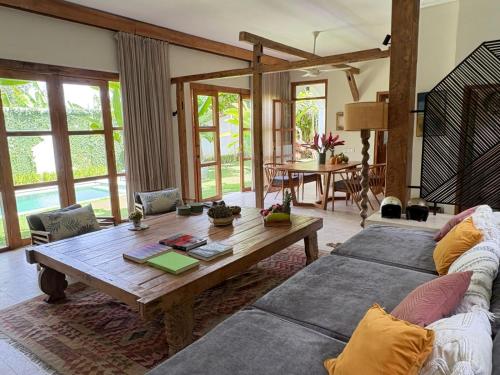 a living room with two couches and a wooden table at Tropical Villa Canggu Beach in Dalung
