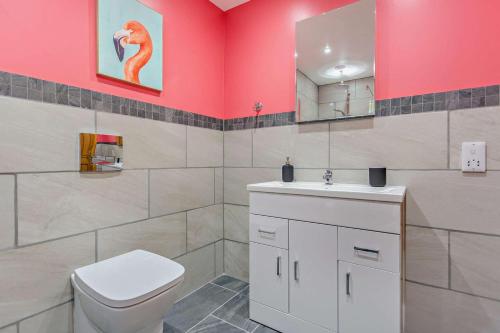 a bathroom with a white toilet and a pink wall at 1 Bed in Strathpeffer oc-h30077 in Strathpeffer